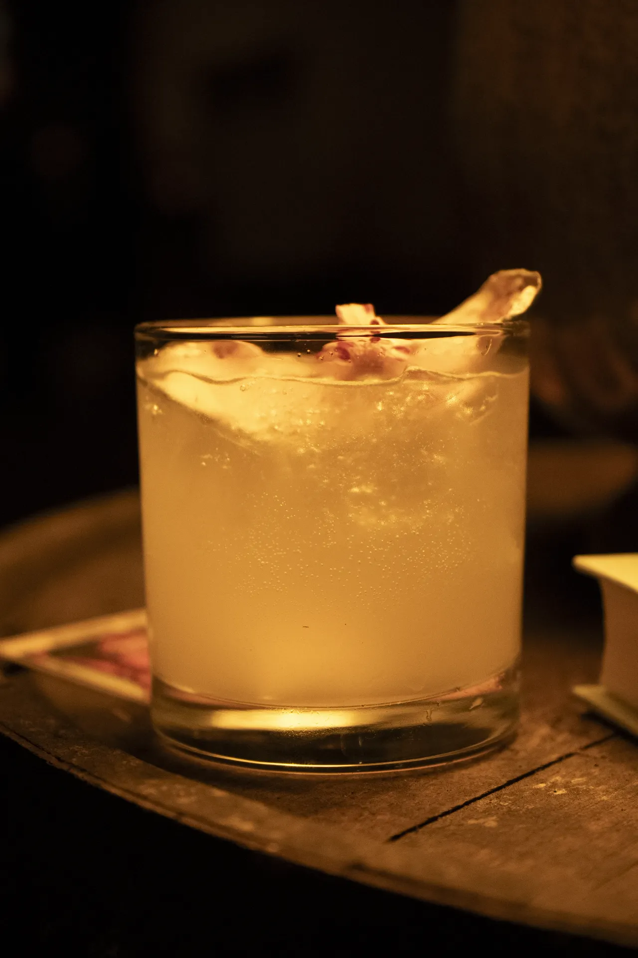 A golden cocktail with citrus garnish on a wooden table at Tequila Town